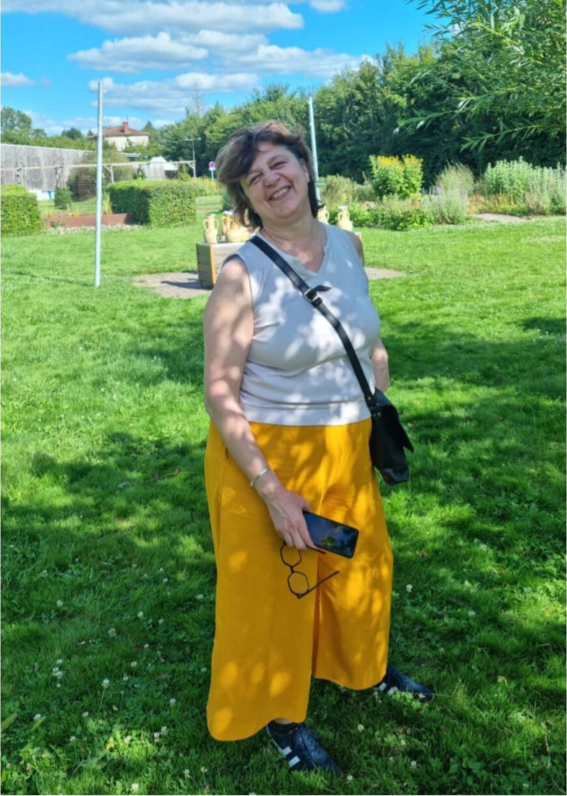 Andreea Delamare souriante dans un jardin ensoleillé